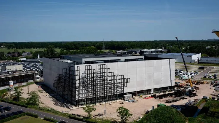 Luftaufnahme der Corda Arena in Hasselt während der Bauphase, mit dem charakteristischen Gitterraster aus Würfeln an der Fassade.
